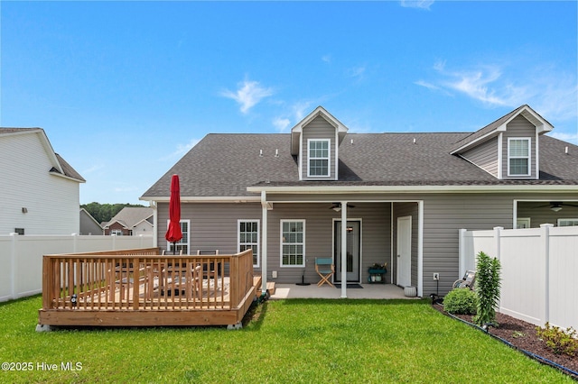 rear view of property with a ceiling fan, roof with shingles, a wooden deck, and a patio