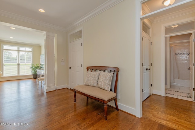 living area with crown molding, wood finished floors, baseboards, decorative columns, and recessed lighting