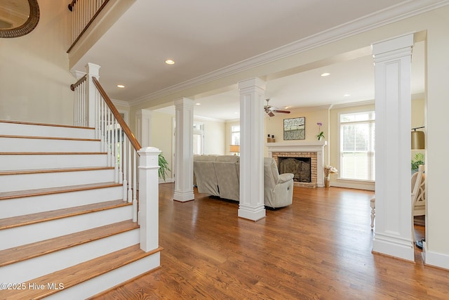 stairs featuring a ceiling fan, ornamental molding, plenty of natural light, wood finished floors, and recessed lighting
