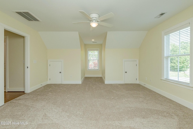 additional living space featuring carpet flooring, vaulted ceiling, a ceiling fan, and plenty of natural light