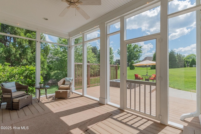 sunroom / solarium featuring a ceiling fan and plenty of natural light