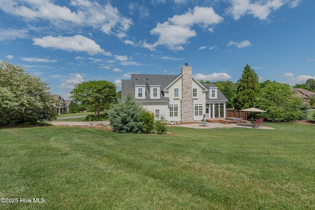 back of house with a patio area, a lawn, a chimney, and an outdoor hangout area