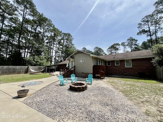 back of house featuring an outdoor fire pit, crawl space, a patio, and brick siding