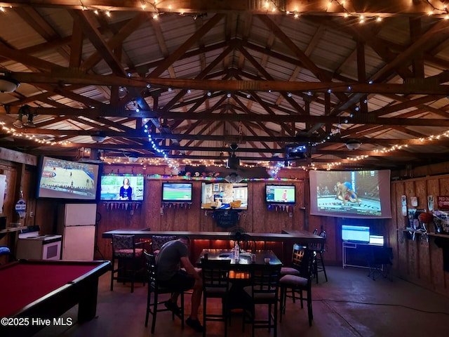 game room featuring a bar, vaulted ceiling, wood walls, concrete flooring, and pool table