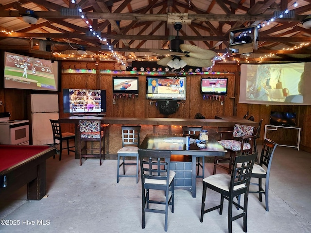 game room featuring unfinished concrete floors, lofted ceiling, wood walls, and pool table