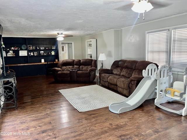 living area with ceiling fan, wood finished floors, a textured ceiling, and ornamental molding