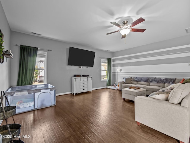 living room with dark wood-style floors, a ceiling fan, and baseboards