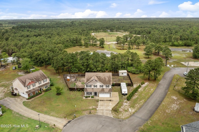 aerial view of property and surrounding area with a heavily wooded area