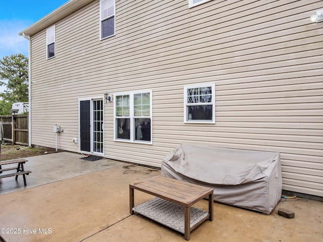rear view of property featuring a patio and fence