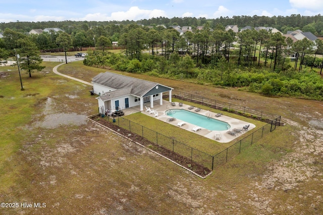 view of subject property with a pool and a tree filled landscape