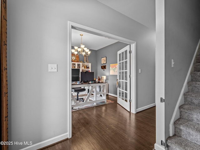 dining room featuring wood finished floors, a desk, a chandelier, stairs, and baseboards