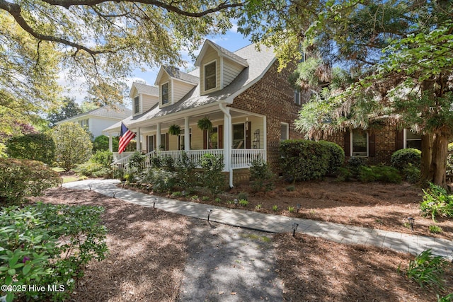 view of front of home featuring covered porch and brick siding
