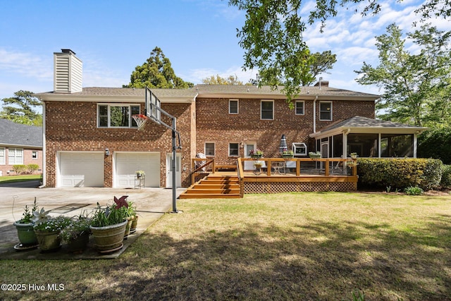 back of property with a chimney, concrete driveway, a sunroom, and brick siding