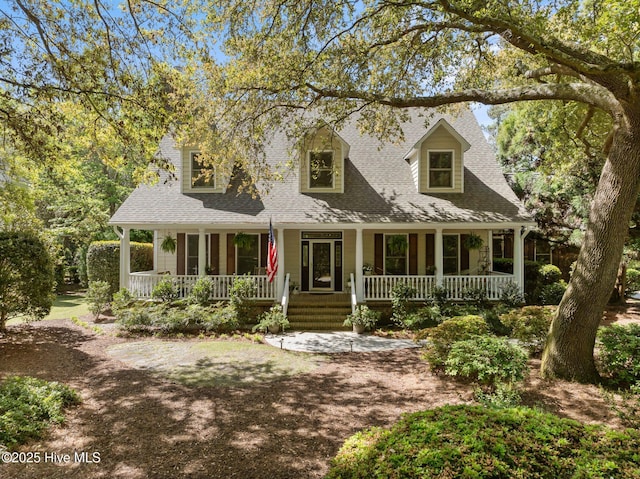 cape cod house featuring covered porch and a shingled roof