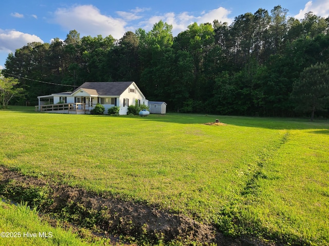 113 Publo Rd, South Mills, NC 27976 - view of green lawn featuring a storage unit, an outbuilding, and a view of trees