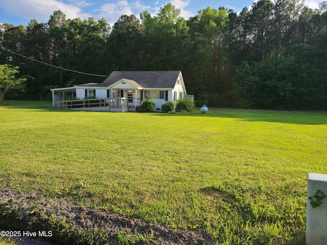 113 Publo Rd, South Mills, NC 27976 - single story home with a front lawn, a wooden deck, and a wooded view