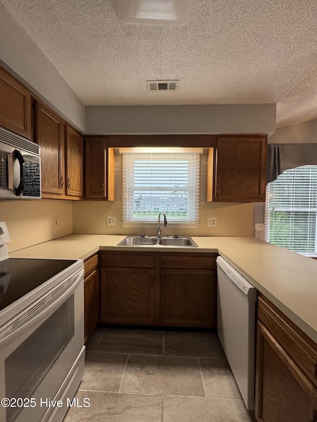 126 W Victoria Ct Unit D, Greenville, NC 27834 - kitchen featuring white appliances, a sink, a textured ceiling, light countertops, and light tile patterned flooring