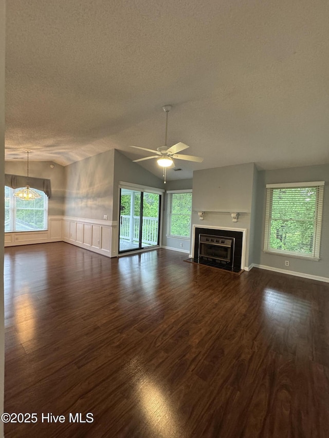 126 W Victoria Ct Unit D, Greenville, NC 27834 - unfurnished living room with a textured ceiling, dark wood-style floors, ceiling fan, a fireplace with flush hearth, and a wainscoted wall