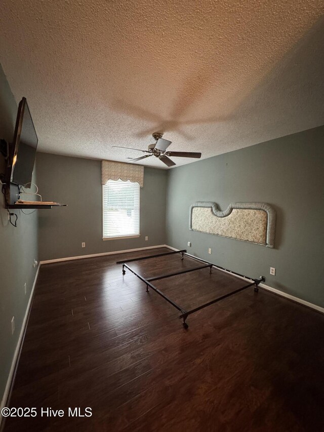 126 W Victoria Ct Unit D, Greenville, NC 27834 - unfurnished bedroom featuring a textured ceiling, wood finished floors, baseboards, and ceiling fan