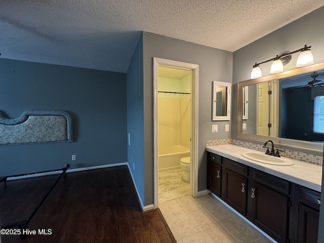 126 W Victoria Ct Unit D, Greenville, NC 27834 - full bathroom with a textured ceiling, vanity, decorative backsplash, toilet, and wood finished floors