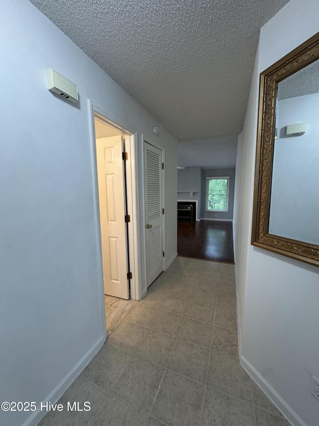 126 W Victoria Ct Unit D, Greenville, NC 27834 - hall with a textured ceiling, baseboards, and tile patterned floors