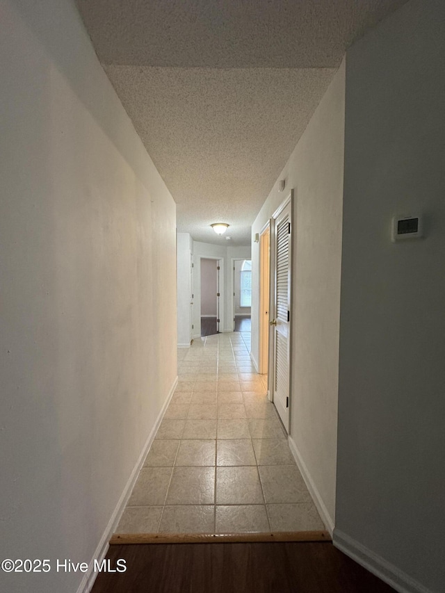 126 W Victoria Ct Unit D, Greenville, NC 27834 - hall with baseboards, a textured ceiling, and light tile patterned floors