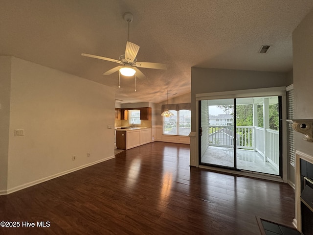 126 W Victoria Ct Unit D, Greenville, NC 27834 - unfurnished living room featuring dark wood finished floors, vaulted ceiling, a ceiling fan, baseboards, and a textured ceiling