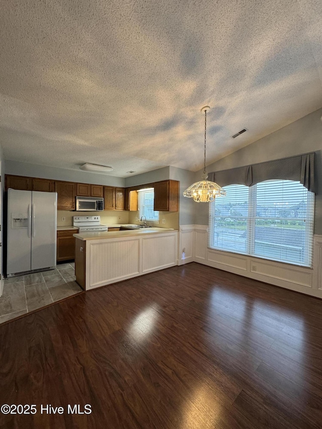 126 W Victoria Ct Unit D, Greenville, NC 27834 - kitchen with white appliances, a textured ceiling, wood finished floors, light countertops, and a chandelier