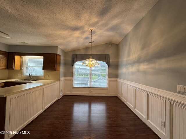 126 W Victoria Ct Unit D, Greenville, NC 27834 - unfurnished dining area featuring a sink, a wainscoted wall, a decorative wall, dark wood-type flooring, and a textured ceiling