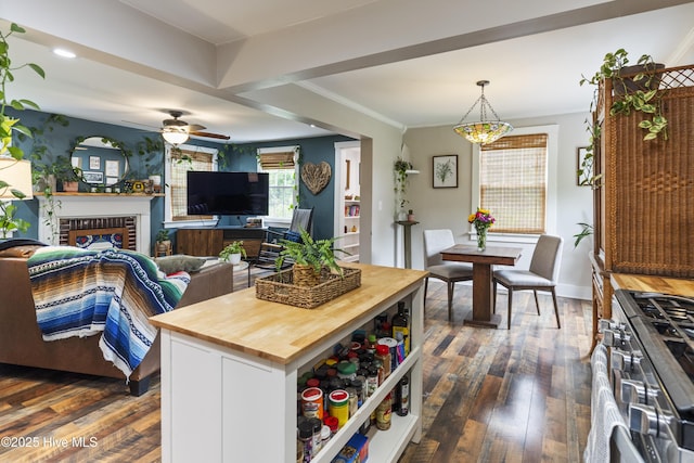 102 E 9th St, Washington, NC 27889 - kitchen featuring butcher block counters, gas range, dark wood-type flooring, decorative light fixtures, and a brick fireplace