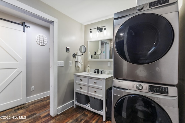 102 E 9th St, Washington, NC 27889 - laundry area with stacked washing machine and dryer, dark wood-type flooring, baseboards, and a barn door