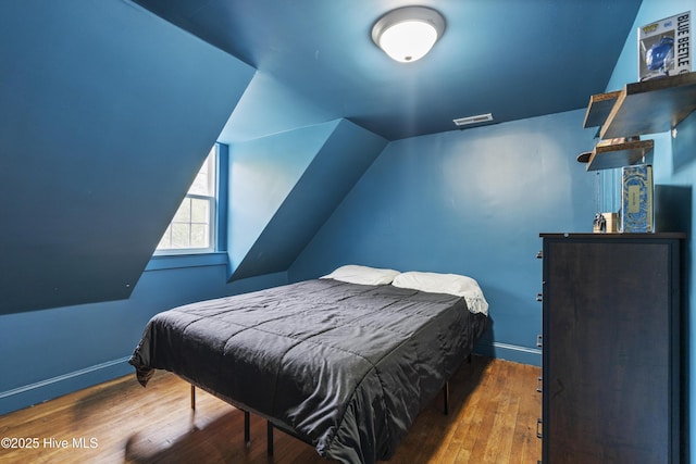 102 E 9th St, Washington, NC 27889 - bedroom with wood finished floors, lofted ceiling, and baseboards