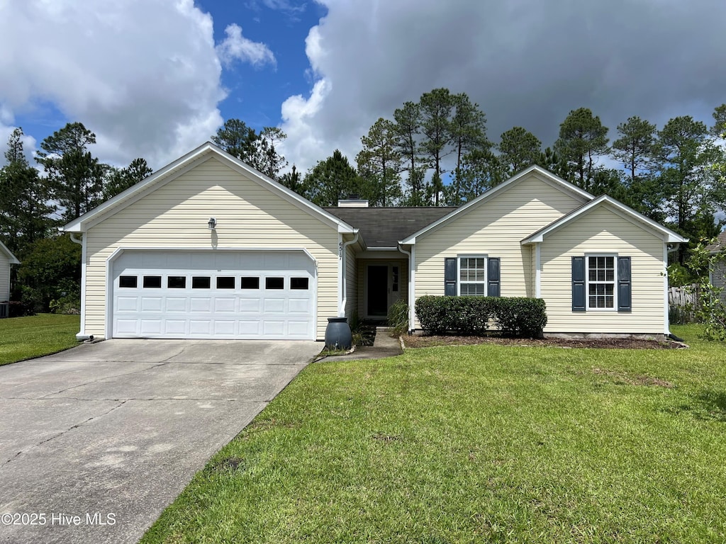 ranch-style home with concrete driveway, an attached garage, and a front lawn
