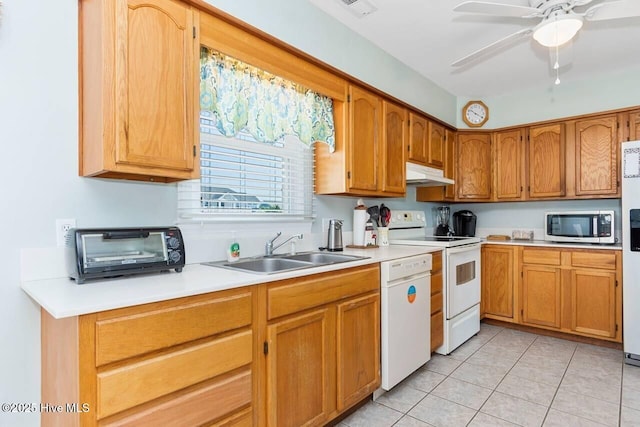 6301 Ocean Dr, Emerald Isle, NC 28594 - kitchen with under cabinet range hood, white appliances, a sink, light countertops, and light tile patterned floors
