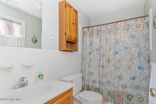 6301 Ocean Dr, Emerald Isle, NC 28594 - bathroom featuring tile walls, toilet, vanity, and a shower with shower curtain