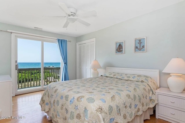 6301 Ocean Dr, Emerald Isle, NC 28594 - bedroom featuring access to exterior, light wood-style floors, a water view, and a closet