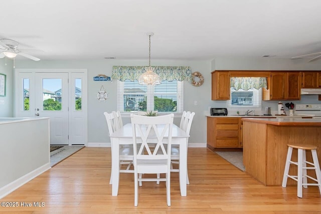6301 Ocean Dr, Emerald Isle, NC 28594 - kitchen featuring white range with electric cooktop, under cabinet range hood, ceiling fan, a chandelier, and light wood-style flooring