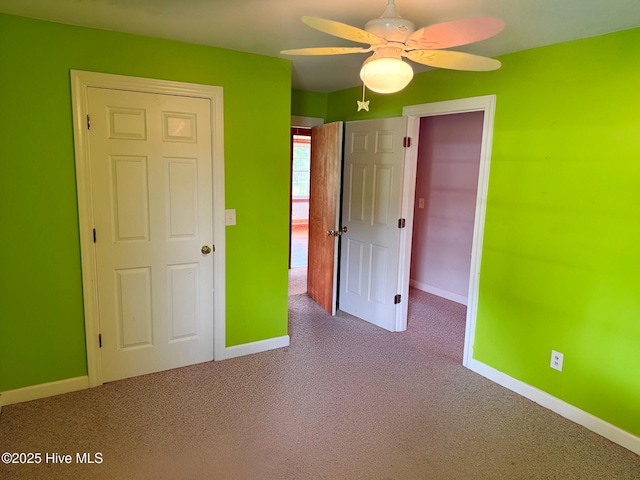 unfurnished bedroom with carpet flooring, baseboards, and a ceiling fan