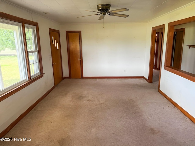 carpeted empty room with baseboards and ceiling fan