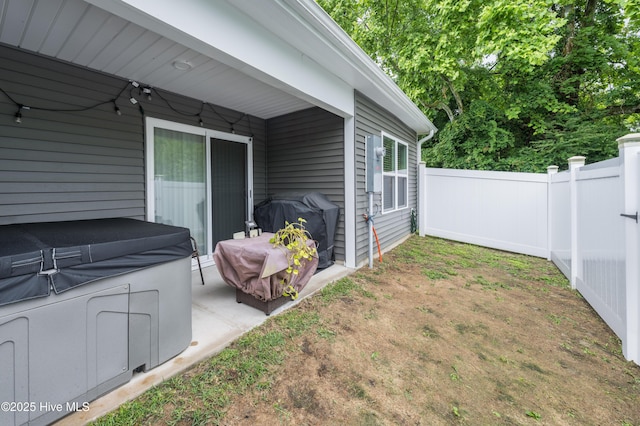 view of yard featuring fence, a hot tub, and a patio area