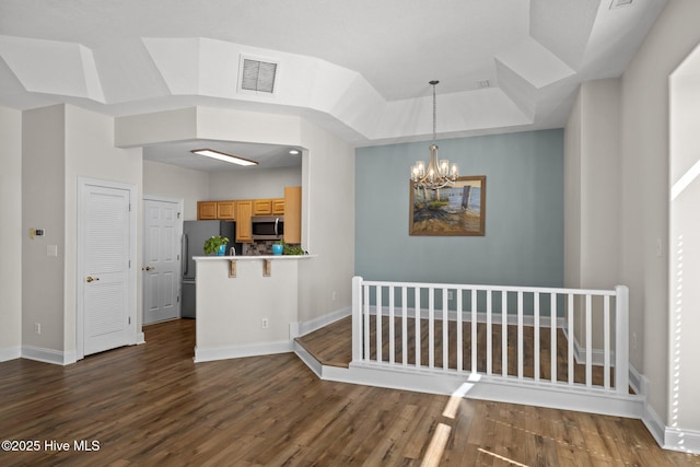 interior space featuring wood finished floors, a chandelier, and baseboards