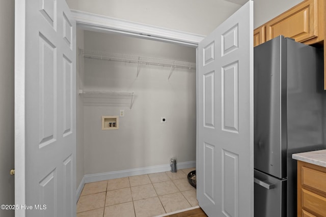 laundry room with hookup for a washing machine, light tile patterned floors, baseboards, and hookup for an electric dryer