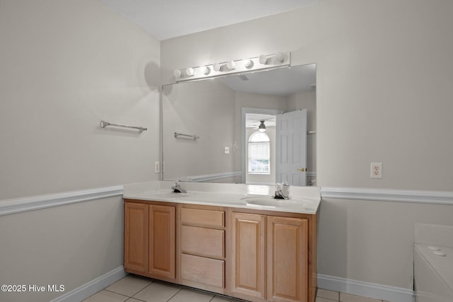 bathroom featuring tile patterned flooring, double vanity, and baseboards