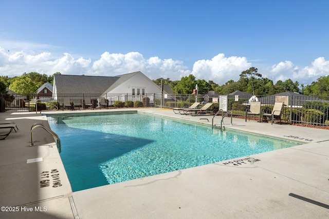 community pool with fence and a patio area