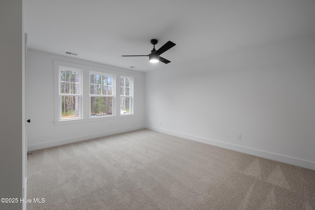 spare room featuring baseboards, light carpet, and a ceiling fan