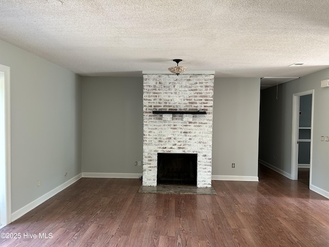 3414 Middle Sound Loop Rd, Wilmington, NC 28411 - unfurnished living room featuring wood finished floors, a textured ceiling, a fireplace, and baseboards