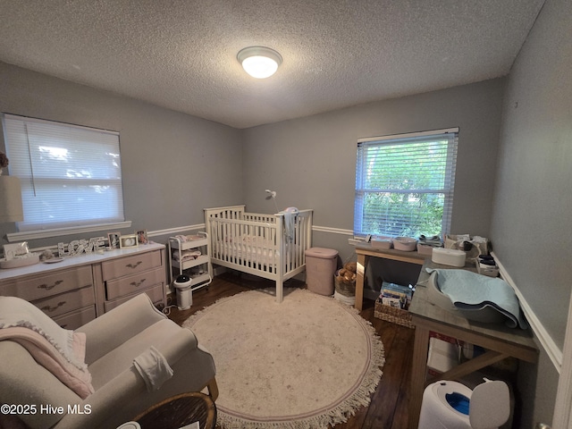 3414 Middle Sound Loop Rd, Wilmington, NC 28411 - bedroom with dark wood finished floors, a textured ceiling, and a crib