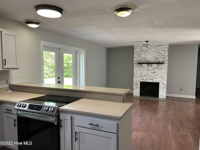 3414 Middle Sound Loop Rd, Wilmington, NC 28411 - kitchen with electric stove, dark wood-style floors, light countertops, a peninsula, and open floor plan