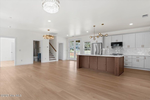 355 S Middleton Dr NW, Calabash, NC 28467 - kitchen featuring a chandelier, black microwave, freestanding refrigerator, light countertops, and recessed lighting