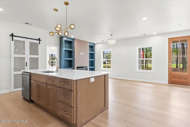355 S Middleton Dr NW, Calabash, NC 28467 - kitchen with a chandelier, a sink, light wood-type flooring, light countertops, and a barn door